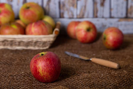 Ripe apples on burlap and in a basket. Rustic style, close-up.の写真素材