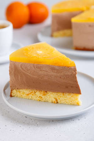 Chocolate-orange mousse cake with biscuit base, jelly and orange circles. Piece of homemade...