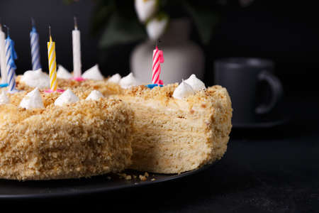Whole holiday cake with crumbly shortcrust pastry and mini meringue. Birthday cake with extinguished candles. homemade baking. Black background, selective focus, close-up.の写真素材