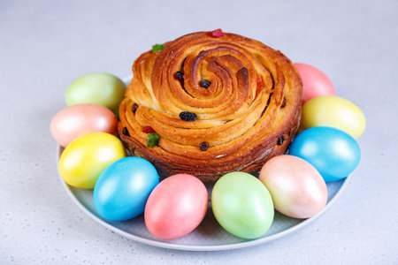 Craffin (Cruffin) with raisins and candied fruits. Traditional Easter Bread Kulich and painted eggs on a gray background. Easter Holiday. Close-up, selective focus.の写真素材