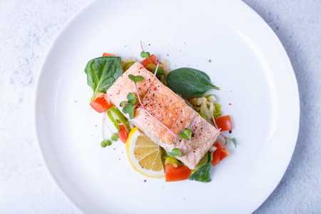 Trout (salmon) with vegetables, lemon and microgreens, cooked by the confit method. Traditional French dish. Step by step. Close-up.の写真素材