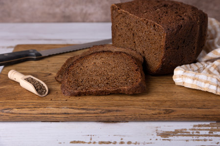 Rye Borodino (Borodinskiy) bread with a crispy crust on a wooden board, cut into slices. Homemade...