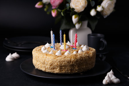 Whole holiday cake with crumbly shortcrust pastry and mini meringue. Birthday cake with extinguished candles. Homemade baking. Black background, selective focus, close-up.の写真素材