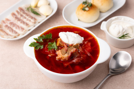 Borsch with pampushki (buns), sour cream, lard and garlic. Traditional Russian and Ukrainian soup with meat, beets, cabbage and potatoes. Close-up, selective focus.の写真素材