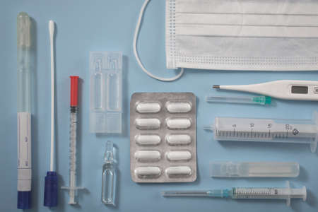 View from above. medical supplies, mask, syringe, ampoule with medicine or vaccine, thermometer, pills. Flat medical viewの写真素材