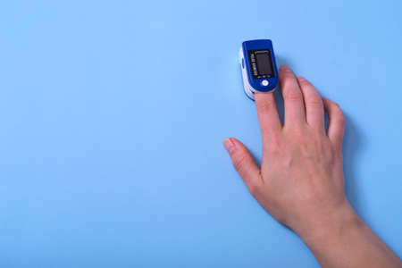 A pulse oximeter is on the woman's hand. A pulse oximeter used to measure heart rate and oxygen levelsの写真素材