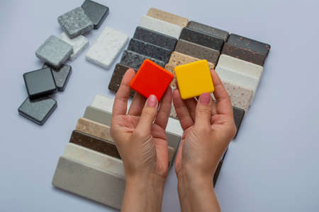 Mock up from natural stones, top view, close-up. Female hands advertises repair materials. Floor tiles, tiles, countertops.の写真素材