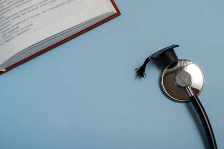 medical education. stethoscope, book and graduate hat. medical concept on blue background. graduateの写真素材
