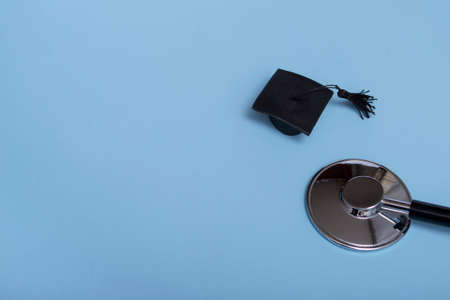 Stethoscope and graduate hat, on a blue background, top view, medical background graduate achievement, backgroundの写真素材