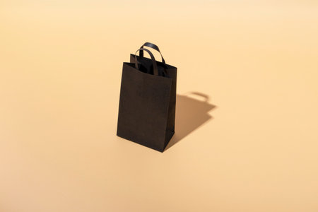 Black craft bag with black handles on a beige background. Black friday concept. Big Saleの写真素材