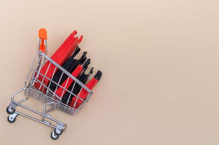Black friday concept, mockup of paper black and red shopping bags with trolley on colored background. Black Friday sale.の写真素材