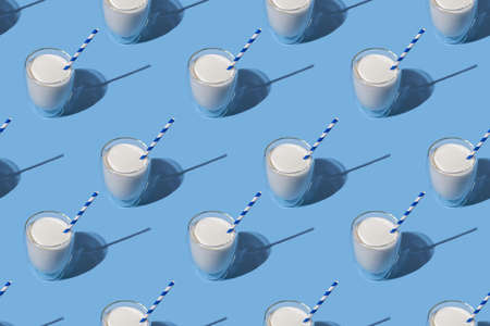World Milk Day. Pattern on a blue background. A glass of milk with a straw. Sample. Package. Layoutの写真素材