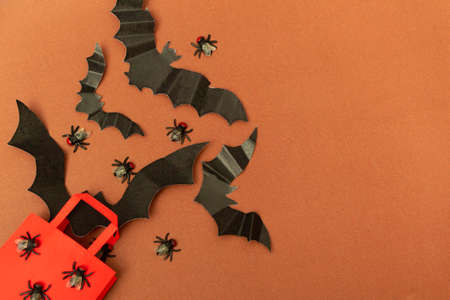 Top view on brown background red package with flies and bats. Close up halloween party