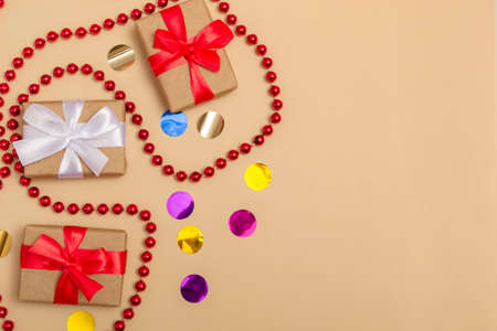New Year 2022. Top view New Year mockup on beige background: red ribbon, gift box, gold numbers and...