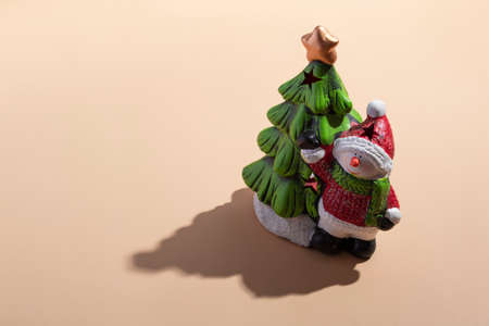 New Year's card close-up: a snowman with a Christmas tree on a beige background with a hard shadow. View from aboveの写真素材