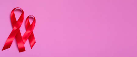 Top view on pink background with red ribbon concept December 1st International AIDS Day close-up....
