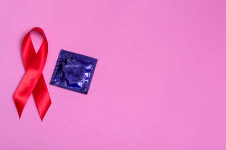 Top view on pink background with red ribbon and conservative concept December 1st International AIDS...
