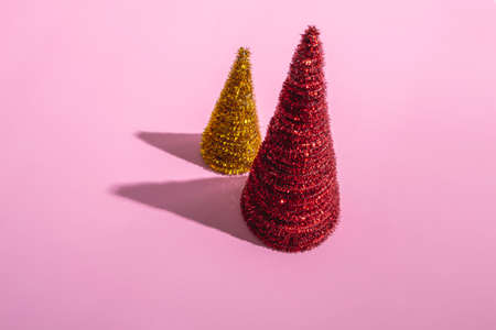 Colored Christmas trees on a pink background. Christmas concept with copy space