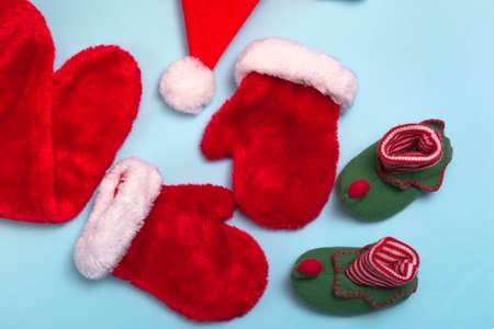 Santa Claus hats, mittens and socks mockup on blue background. Christmas flat mockup, close up top viewの写真素材