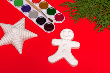 Christmas decorative gingerbread man, star and paints, creativity concept on a red background with a...