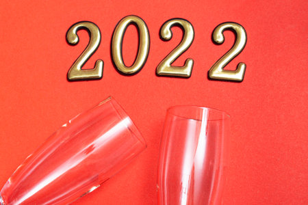 Top view flat new year mockup on red background with numbers, champagne and glasses. Close-up. New...