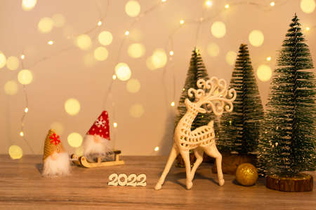 Christmas and New Year's decor. Christmas deer, numbers 2022, gnome on a sled and Christmas trees on...