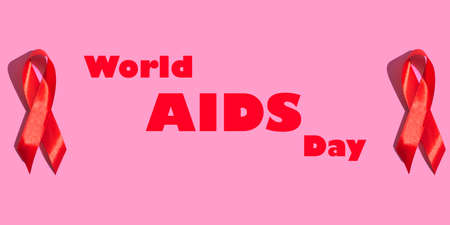 International AIDS Day. Red ribbon with a hard shadow on a pink background. AIDS awareness concept....