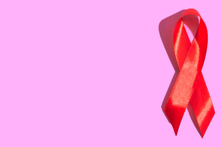 International AIDS Day. Red ribbon on a beige background close up.Banner. AIDS awareness concept. December 1. Copy spaseの写真素材