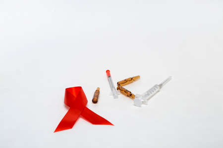 Medical concept december world aids day. Red tape, ampoules of medicine and syringe on a white background. Safe sex concept.の写真素材