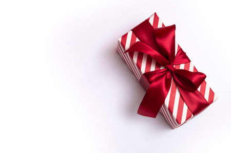 Striped gift box with a red bow on a white background. closeup.の写真素材