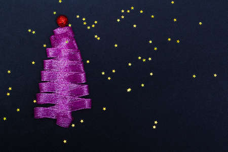 Purple Christmas tree made from ribbon on a black background with stars with copy space. Template for postcards, packaging, advertising.の写真素材