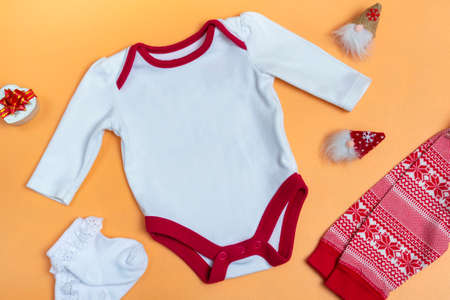 Mockup of a white baby bodysuit on a colored background close-up with red pants and gnomes mockup of clothes for newborns. copy spaceの写真素材