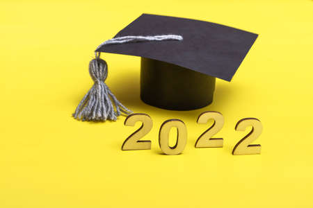 Gift box in the form of a graduation cap. 2022 release concept on yellow background with copy spaceの写真素材