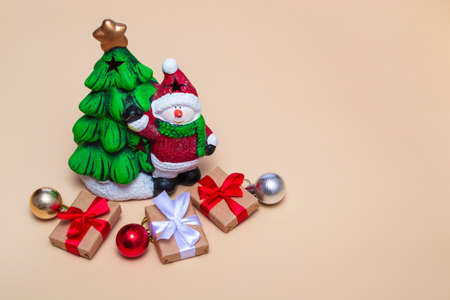 Christmas card. New Year tree with a snowman and gifts on a beige background. Close up with copy spaceの写真素材