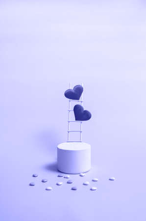 A podium with a wooden staircase and hearts in a trendy color very peri, monochrome. Celebrating Valentine's Day with copy space. Vertical formatの写真素材