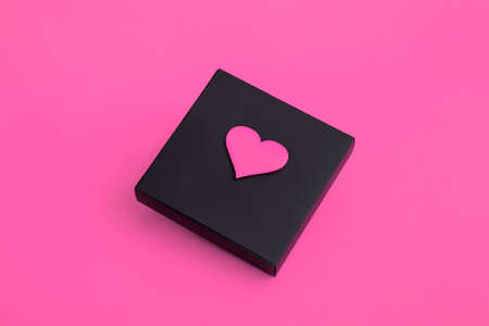 Gift black box with hearts on a pink background. Close up copy spaceの写真素材