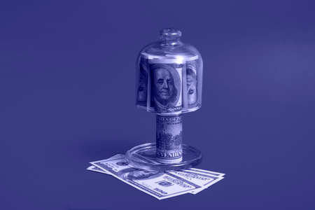 Leasing concept. Shopping cart and piggy bank with dollar bills on very peri background, close up....