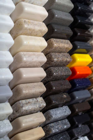 Samples of natural granite, marble, quartz stone, countertops and a sample of natural parquet. Model made of stones, close up. Modern colored slabs made of natural stone. Vertical formatの写真素材