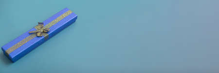 Gift blue box on a turquoise background. Holiday gifts close up with copy space. Bannerの写真素材
