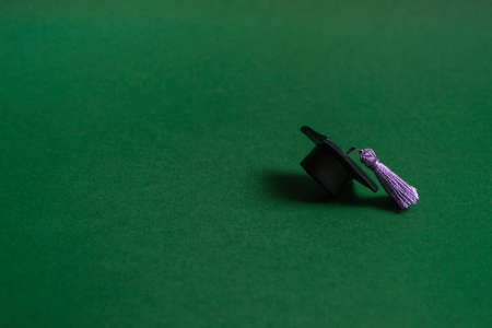 Graduation cap on green background, close up with copy space. Medical education concept.の写真素材
