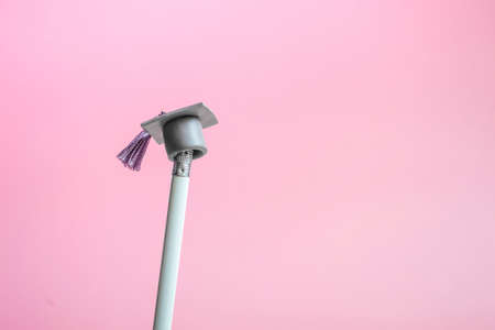 White pencil with graduation hat on a pink background close up with copy space. Education conceptの写真素材