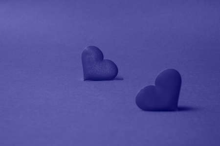 Composition for Valentine's Day. On a very peri background, red hearts close up with copy space