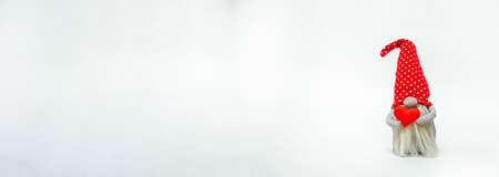 Leprechaun in a red hat with a red heart in his hands, isolated on a white background. Idea valentines dayの写真素材