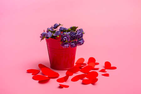 Bouquet of blue roses in a red decorative bucket with paper hearts on a pink background. concept for valentines day or mothers dayの写真素材