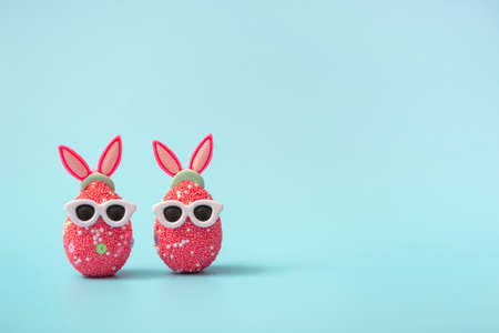 Colorful Easter egg with bunny ears and sunglasses on a blue background. Sale banner, mockup...