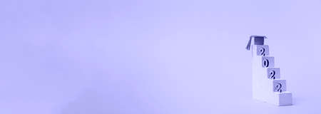 A simple concept of education on a very peri. Graduation 2022. Podium steps with graduation cap and...