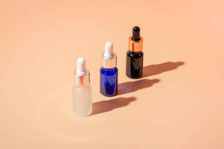 Cosmetic bottle mockup with cosmetics on beige background with hard shadows, close up copy spaceの写真素材