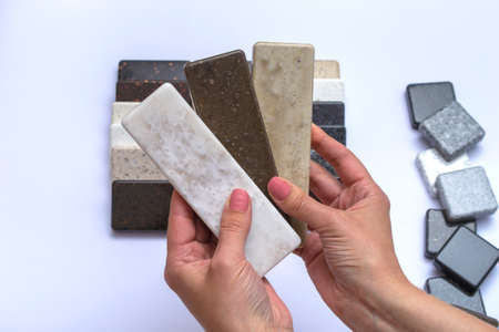 Mock up from natural stones, top view, close up. Female hands advertises repair materials. Floor tiles, tiles, countertops.の写真素材