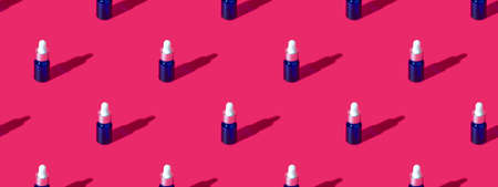 Cosmetic bottle mockup with cosmetics on pink background with hard shadows, copy space close up....