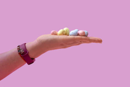Natural colored quail eggs in a female hand on a pink background. Banner. Close upの写真素材
